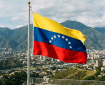 Venezuelan flag flying above Caracas with mountains and city below